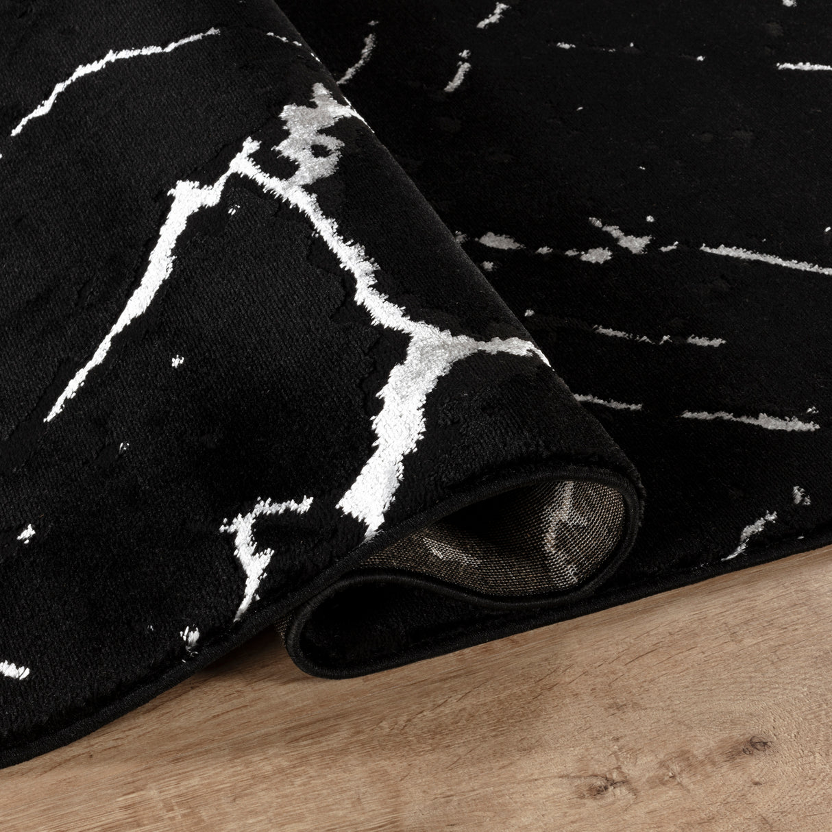 Black and white patterned rug on a wooden floor