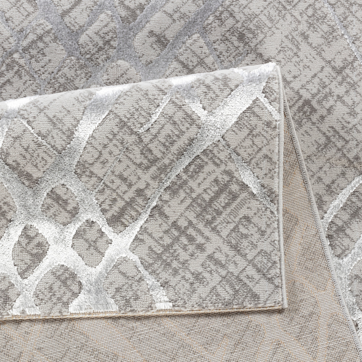 Close-up of a textured gray and white rug with geometric pattern