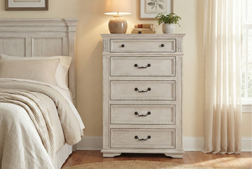 Neatly made bed with beige bedding and a matching nightstand in a bedroom setting.