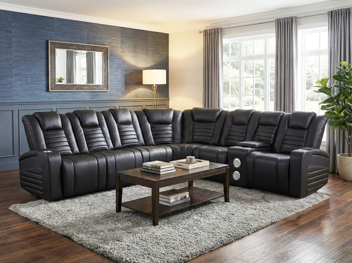 Black leather sectional sofa in a living room with a coffee table and decor.