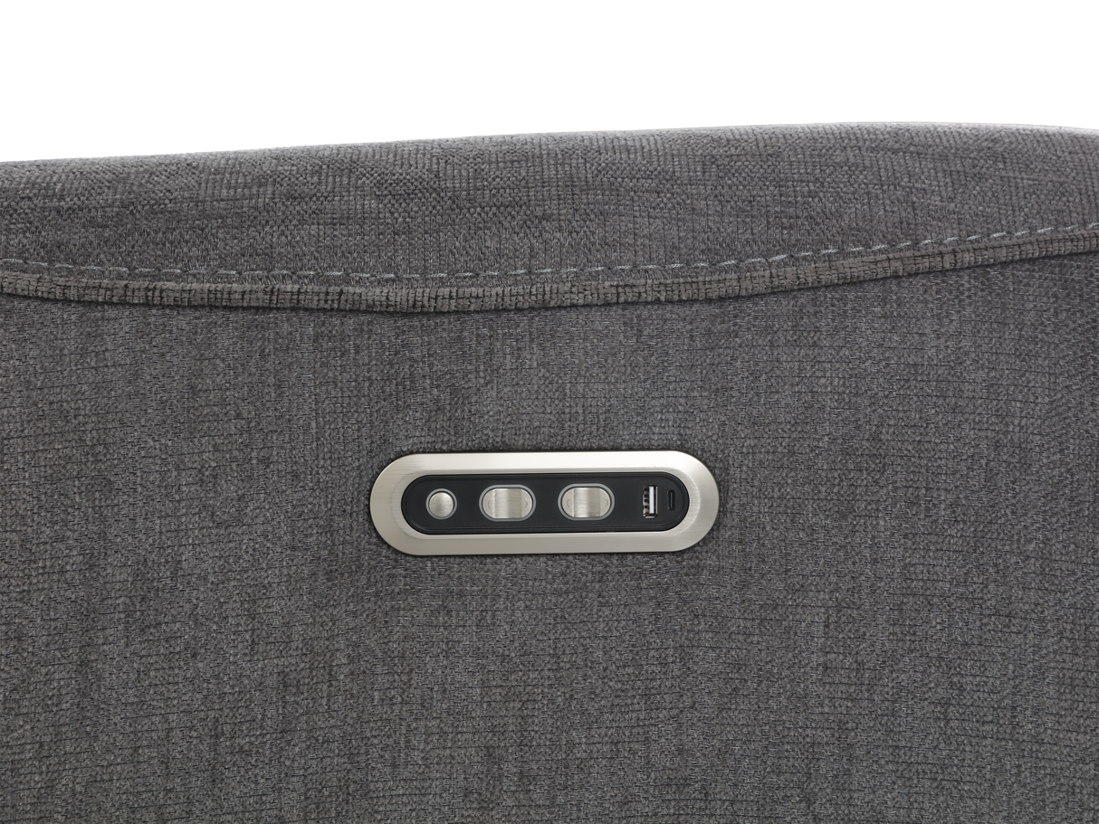 Close-up of a gray fabric surface with a control panel featuring three buttons.