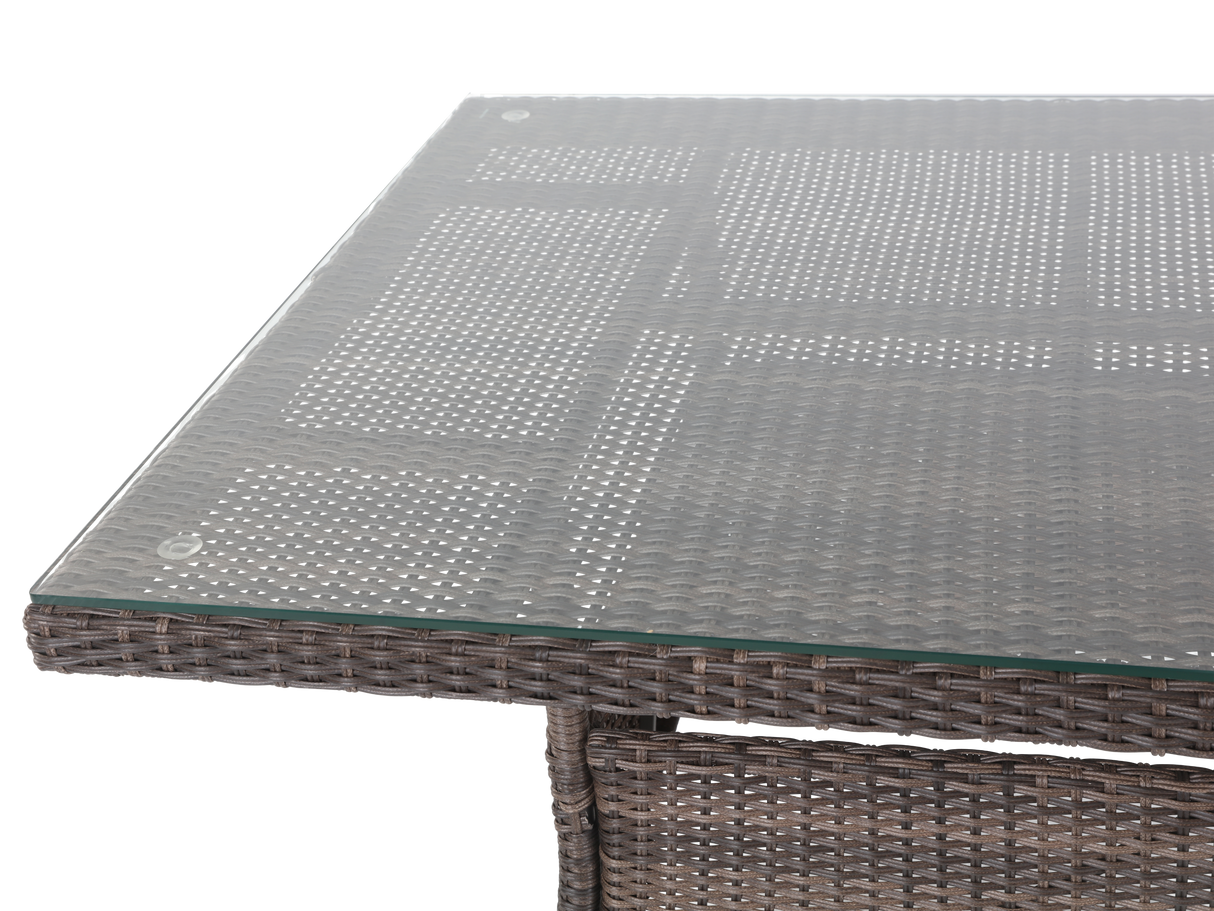 Glass-top outdoor table with wicker frame on a white background