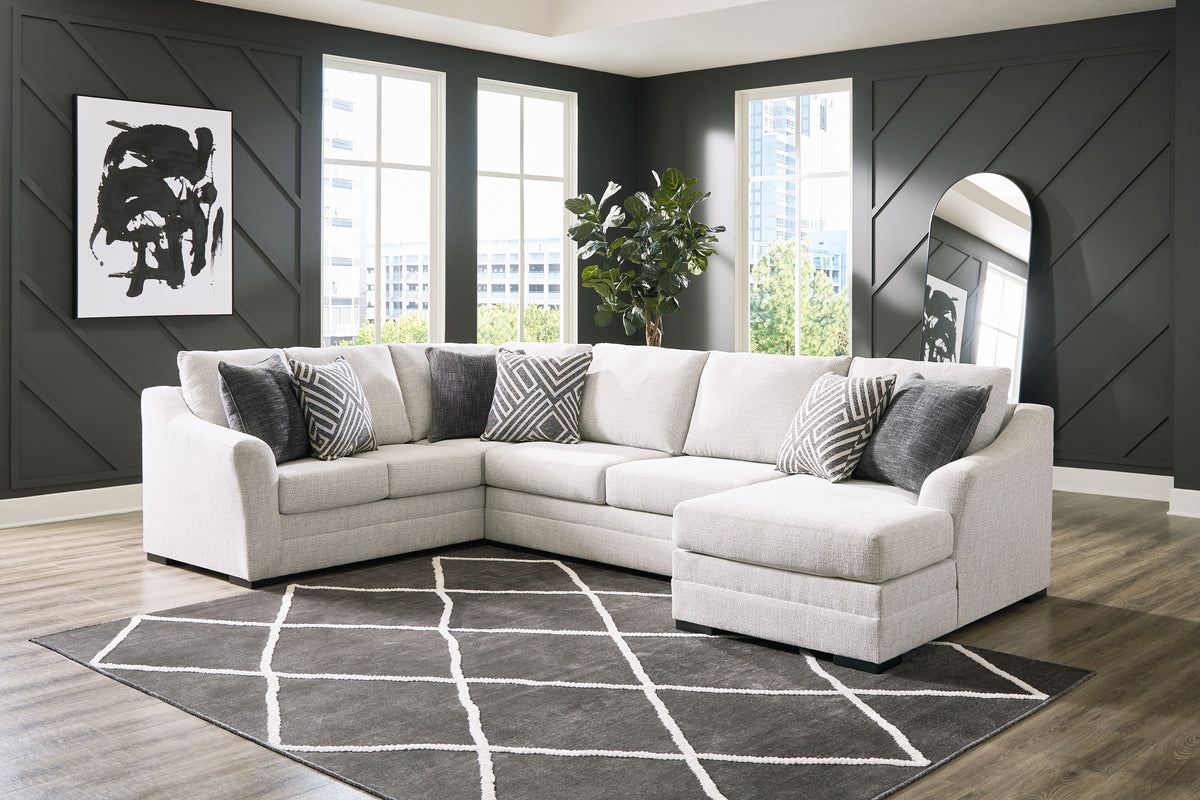 Koralynn light gray sectional with chaise in a living room with dark paneled walls and a patterned rug