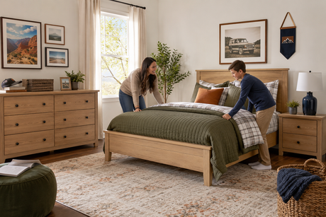 Parent and school-age child making a full bed in a coordinated neutral bedroom set