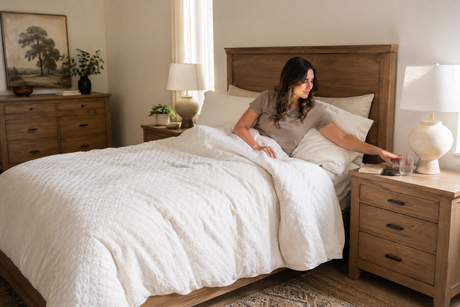 Woman reaching toward a properly sized nightstand beside a bed