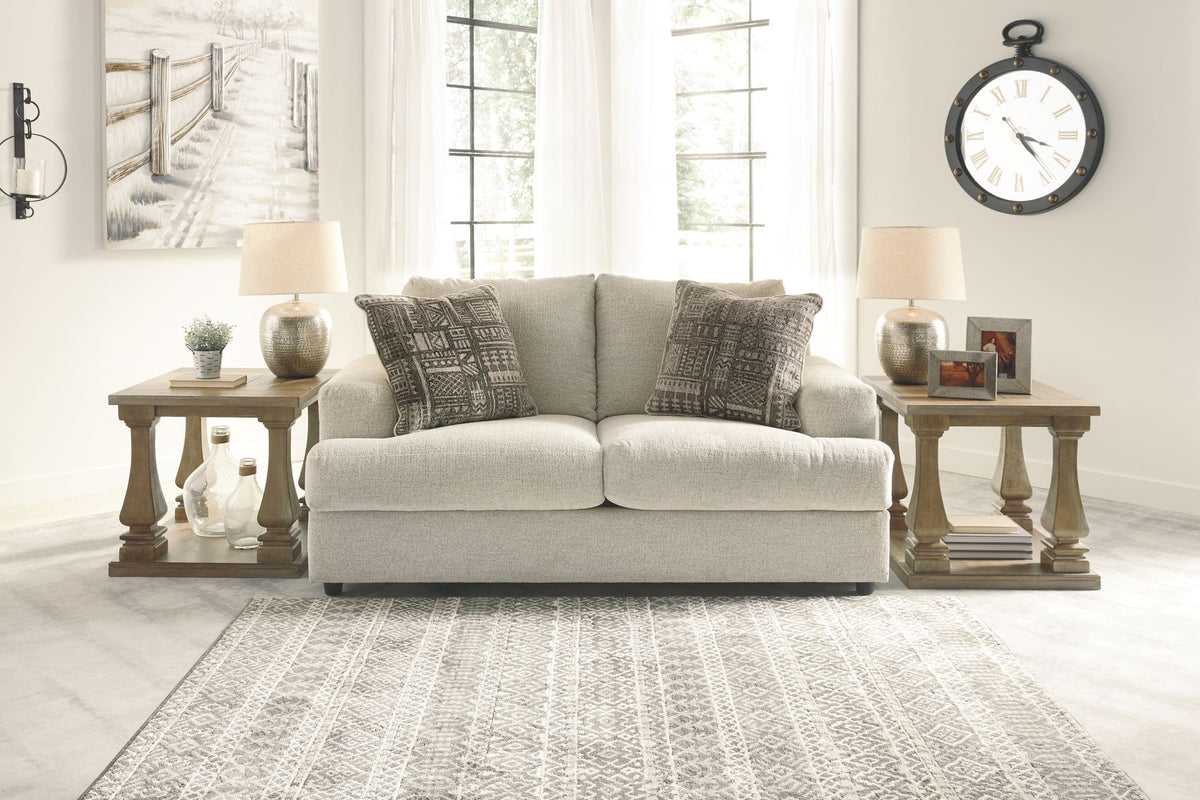 Living room with a beige sofa, side tables, and decorative items.