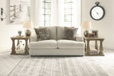 Living room with a beige sofa, side tables, and decorative items.