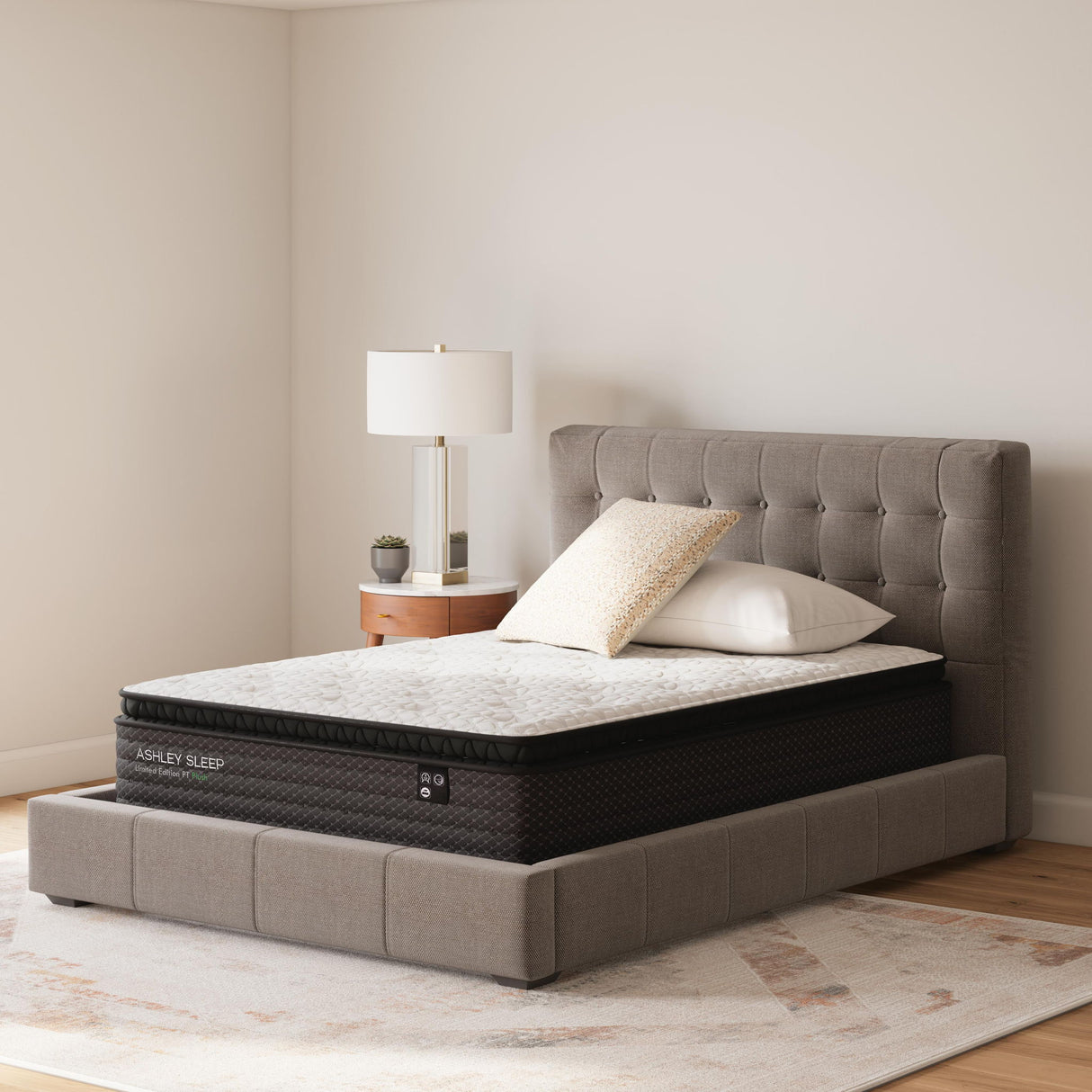 Limited Edition Pt pillow top mattress by Sierra Sleep on gray upholstered bed frame with bedside table - Bel Furniture