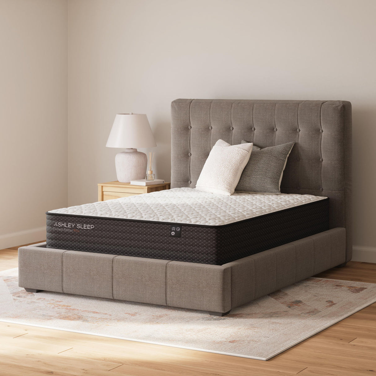 Sierra Sleep Limited Edition Firm innerspring mattress on gray upholstered bed frame with pillows - Bel Furniture