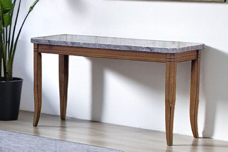 Set of wooden coffee tables with marble-like tops in a room with a large window and plant.