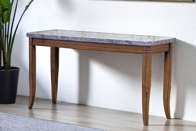 Set of wooden coffee tables with marble-like tops in a room with a large window and plant.