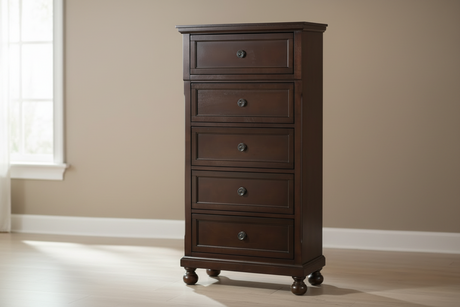 Wooden dresser in a bedroom setting with a bed and lamp in the background.