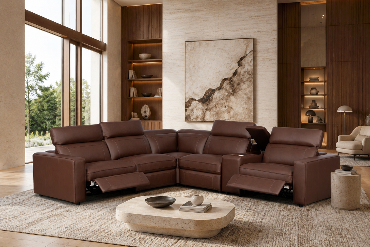 A large brown leather sectional sofa with reclining seats and extended footrests, staged in a modern living room with a stone coffee table, shelving, and wall art.