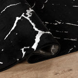 Black and white patterned rug on a wooden floor