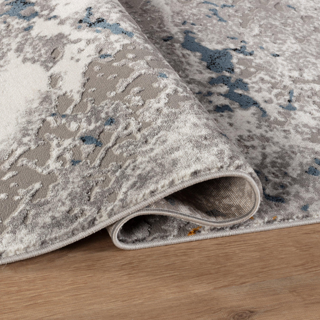 Gray and beige patterned rug on a wooden floor