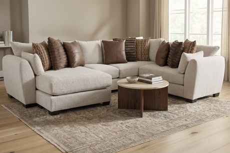Beige sectional sofa with brown throw pillows in a living room setting.