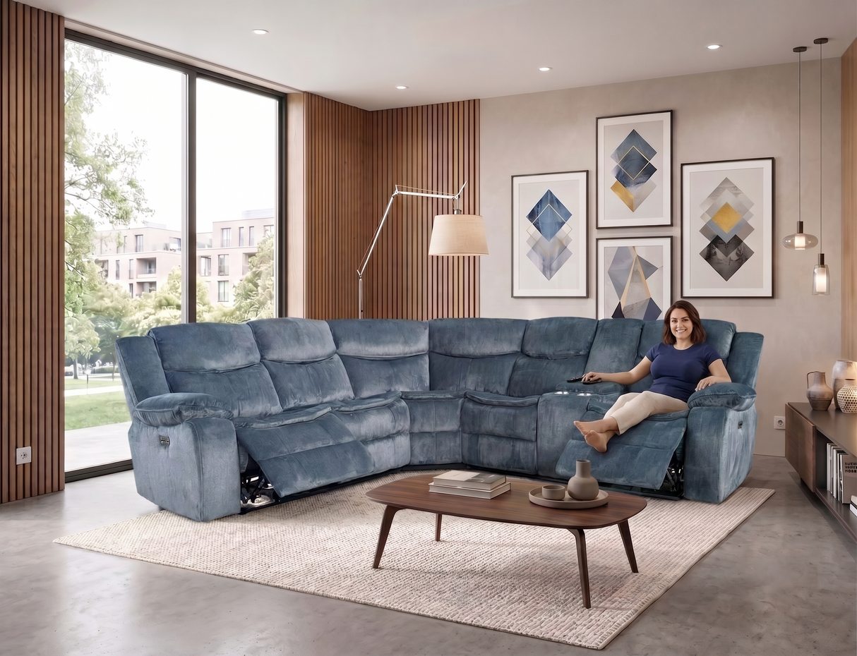 A woman reclines in a large blue sectional sofa in a modern living room with wood slat walls, framed abstract art, a coffee table, and a light rug.
