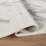 Close-up of a textured rug with a subtle pattern on a wooden floor.