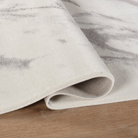 Close-up of a textured rug with a subtle pattern on a wooden floor.