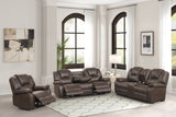 Brown leather reclining sofa set in a living room with large windows.