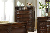 Luxury bedroom set with dark wood furniture including a bed, dresser, and nightstands.