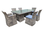 Outdoor furniture set with a glass table and wicker chairs on a white background