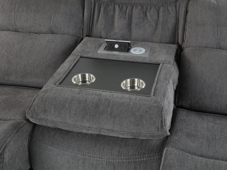 Gray sectional sofa with a built-in pet bed and food bowls.