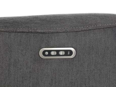 Close-up of a gray fabric surface with a control panel featuring three buttons.