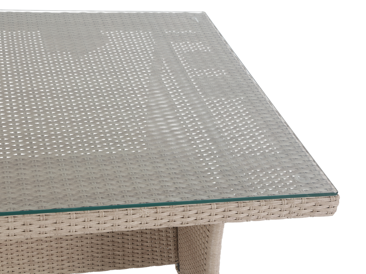 Outdoor furniture table with woven frame and glass top on a white background