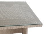Outdoor furniture table with woven frame and glass top on a white background