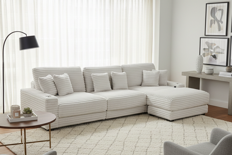 Modern living room with a striped sectional sofa, coffee table, and decorative items.