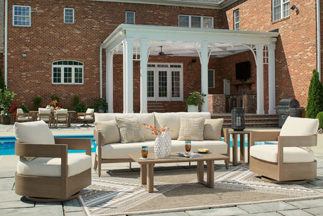 Outdoor patio set with furniture and decor in front of a brick house.