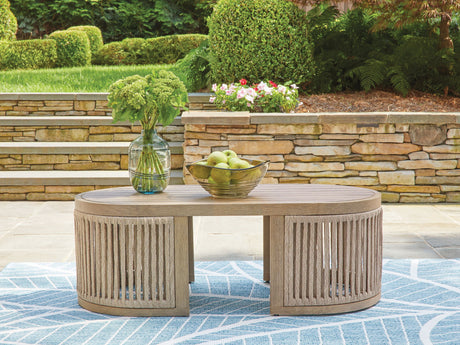 Round outdoor coffee table with decorative items on a patio
