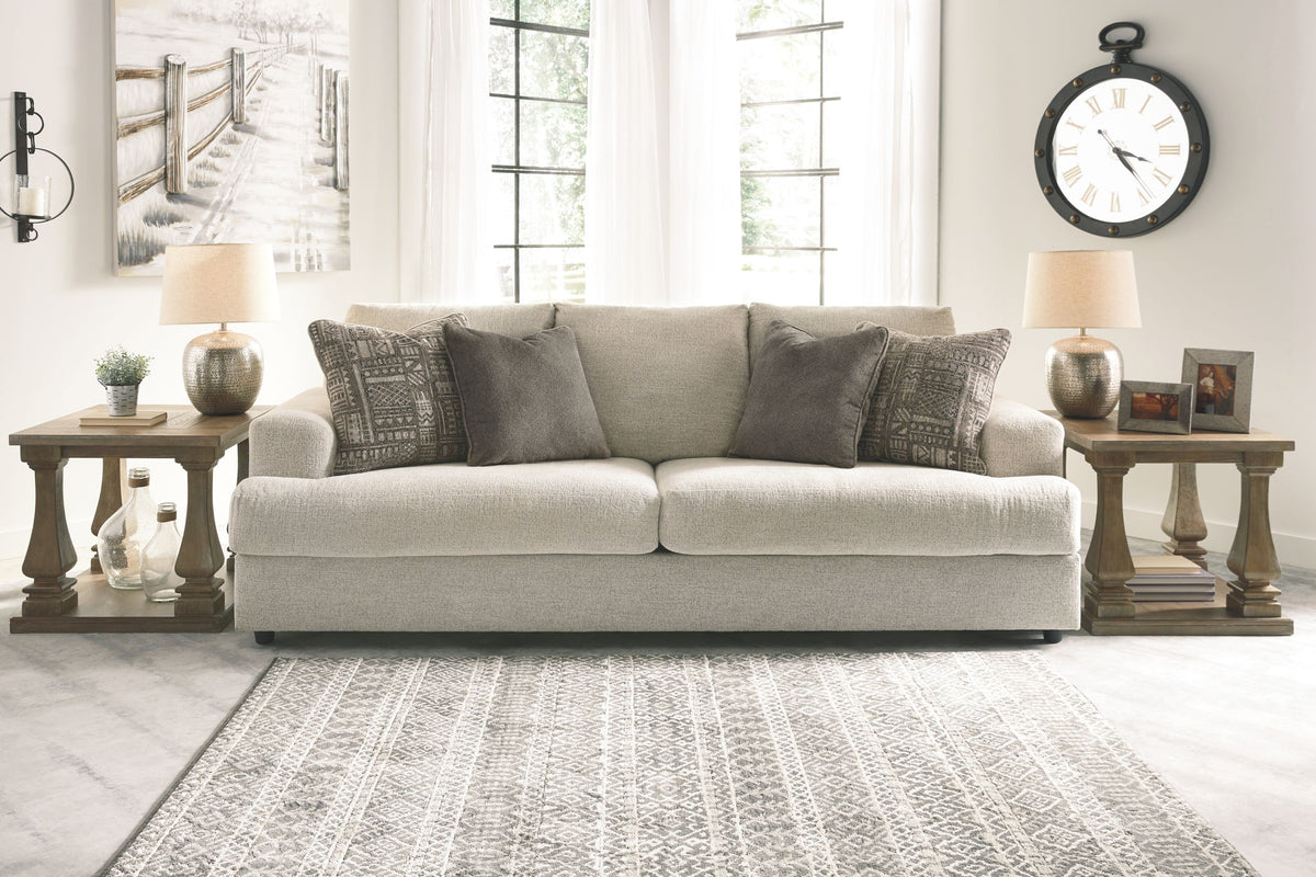 Living room with a beige sofa, decorative pillows, and side tables.